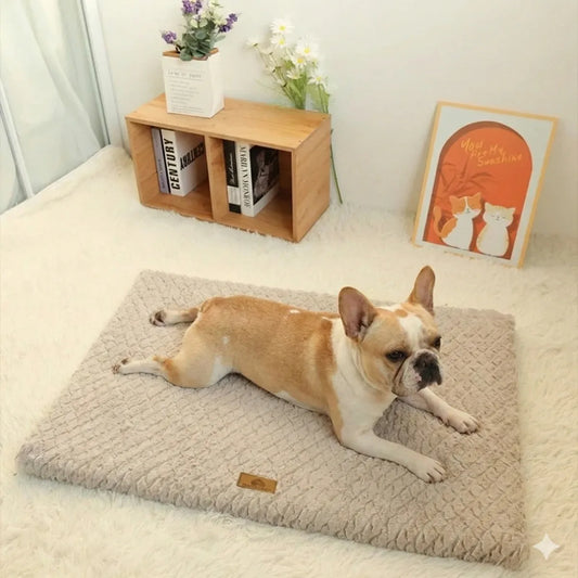 Bouledogue français couché confortablement sur un tapis pour chien beige texturé.