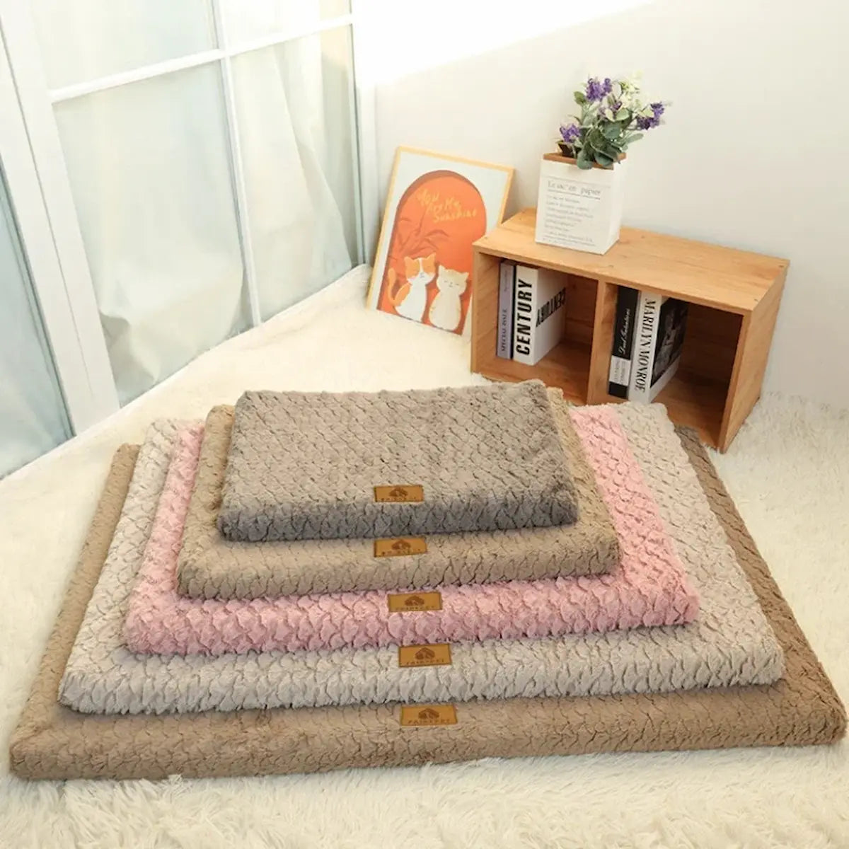 Pile de tapis pour chien moelleux et texturés montrant les différentes tailles et couleurs disponibles.