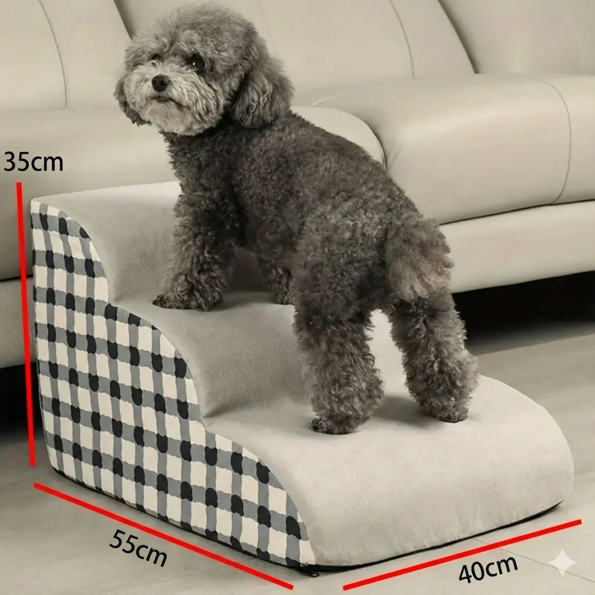 Petit chien gris montant sur un escalier pour chien en mousse à motif carreaux devant un canapé, avec dimensions affichées 35cm de hauteur.