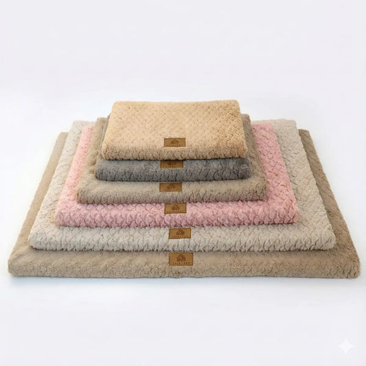 Pile de six tapis pour chien moelleux et texturés, présentés du plus petit au plus grand dans différentes couleurs (beige, gris, rose, marron) sur un fond blanc uni.